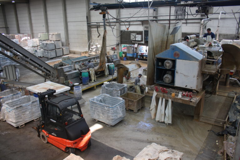 Wasserwerkstatt einer Lederfabrik mit Maschinen, Behältern und Arbeitern in einer großen Industriehalle