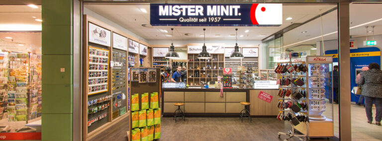 Mister Minit Ladengeschäft mit Schaufenster, Auslagen und Verkaufstheke in einem Einkaufszentrum.